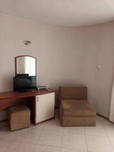 a living room with a chair and a mirror at Къща за Гости ,,Afrikana,, in Sveti Vlas