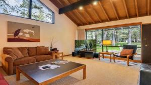 a living room with a couch and a tv at Meadow House 21 in Sunriver