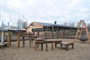 a playground with benches and a swing in the sand at Marinaparcs Naarden in Naarden