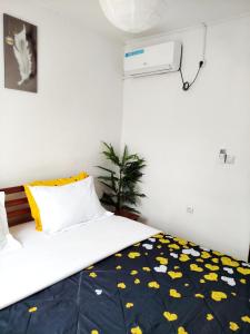 a bedroom with a bed with a blue and yellow blanket at Côté Plage Kribi Studio Soleil in Kribi