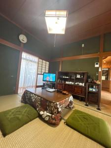 a living room with a table and a tv at 2つの温泉が徒歩圏内にある一棟貸し古民家民宿Honjo no ie駐車場4台無料最大9名宿泊可能 in Yurihonjo
