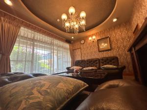 a bedroom with a bed and a table and a chandelier at 2つの温泉が徒歩圏内にある一棟貸し古民家民宿Honjo no ie駐車場4台無料最大9名宿泊可能 in Yurihonjo