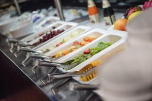 a buffet line with trays of vegetables and fruit at Muttererhof in Innsbruck