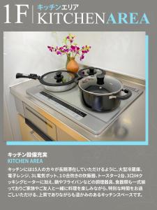Zwei Töpfe mit Blumen stehen auf dem Herd. in der Unterkunft 東京ディズニーリゾートに行く15名までのグループに大好評 ! セブンイレブンまで歩いて1分 Perfect for large group up to 15 persons! Highly Acclaimed Villa Hotel Near Tokyo Disney Resort ! 1 Minute Walk from 7 Eleven in Tokio