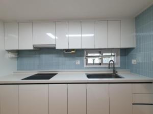 a kitchen with white cabinets and a sink at 상록수 sangroksu in Boeun