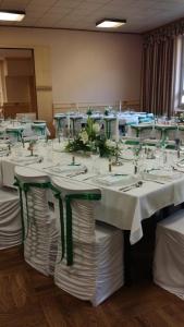 a room with white tables and chairs with flowers on them at Landgasthof Sengstbratl in Wallsee