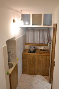 una piccola cucina con armadi in legno e lavandino di Il Piccolo Sogno a Salerno
