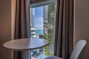 ein Zimmer mit einem Tisch und einem großen Fenster in der Unterkunft Gray 193 Hotel in Busan
