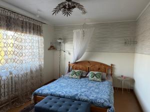 a bedroom with a blue bed and a window at Villa Mariett in Kuressaare