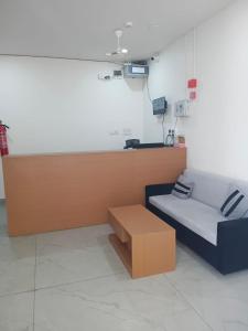 a room with a bed and a bench in it at Hotel Marigold Vasad in Vāsad