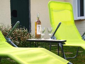 a bottle of wine sitting on a table with two chairs at Chez Béa in Pleumartin +17 photos