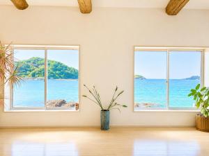 two windows in a room with a view of the ocean at SEABASE villa at shimane in Matsue