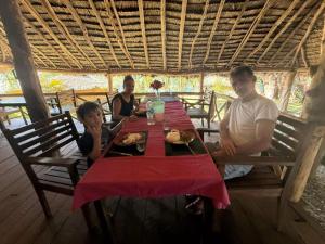 a family sitting at a table with a red table cloth at Fireworks bungalows in White Sands +24 photos