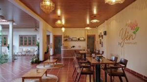 a restaurant with wooden tables and chairs in a room at Yên Retreat & Cafe in Cà Mau