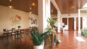 a restaurant with a table and chairs and plants at Yên Retreat & Cafe in Cà Mau +87 photos