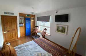 a bedroom with a bed and a tv on the wall at Room Stay 4 in Corran Cross Roads