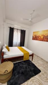 a bedroom with a bed with a yellow blanket on it at the velvet nest in Watamu