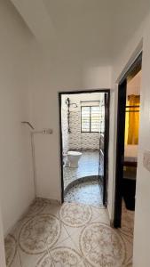 a bathroom with a tub and a toilet in a room at the velvet nest in Watamu +17 photos