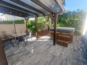a patio with a hot tub and a table at Apartament Chyża , jacuzzi , taras , parking in Zamość +6 photos