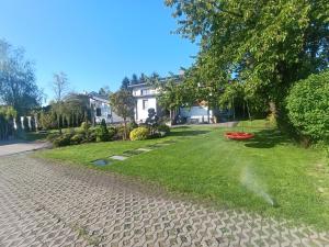 a yard of a house with a cobblestone driveway at Apartament Chyża , jacuzzi , taras , parking in Zamość