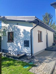 a small white house with a large window at Apartament Chyża , jacuzzi , taras , parking in Zamość