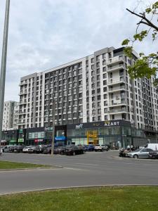 a large building with cars parked in a parking lot at Boulevard terrace apartment in Chişinău