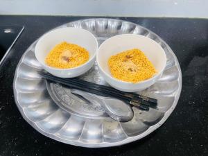 two bowls of food on a glass plate with chopsticks at Nhà nghỉ tam cốc in Ninh Binh