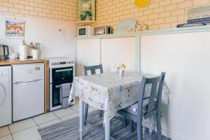 a kitchen with a table with two chairs and a stove at BARHOLM CROFT Holiday Cottage in Creetown +25 photos