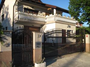 a white house with a gate with a balcony at Apartment Yasica in Izačić