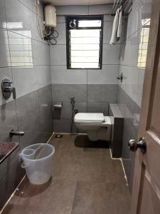 a bathroom with a toilet and a window at Hotel Volga Plaza in Mumbai