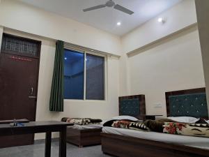 a room with two beds and a table and a window at Krishna palace in Pīpalkoti +50 photos