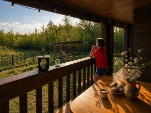 a woman standing on a porch talking on a cell phone at Eco house in Szack +6 photos