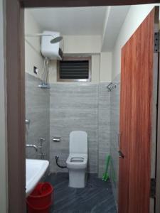 a bathroom with a white toilet and a sink at Demazong Homestay in Ravangla
