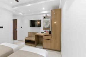 a bedroom with two beds and a desk with a mirror at Hotel Amber Seaside in Hulhumale