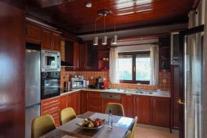 a kitchen with a table with a bowl of fruit on it at Thea Panorama in Makri