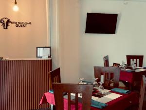 a dining room with tables and chairs and a tv at New National in Pettah