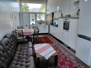 a living room with a couch and a table in a kitchen at Apartman YVET in Sučany