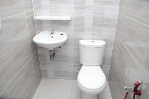 une salle de bains avec toilettes et lavabo dans l'établissement Tanjung Homestay, à Ipoh