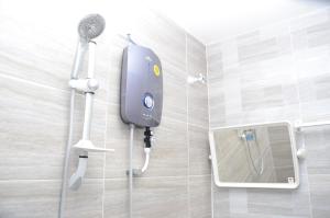 une douche dans une salle de bain avec une pomme de douche dans l'établissement Tanjung Homestay, à Ipoh