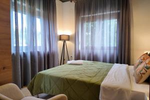 a bedroom with a bed and a window with curtains at Thea Panorama in Makri
