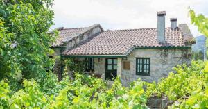 een klein stenen huis in het midden van een veld bij Casa de Pereiró in Soajo