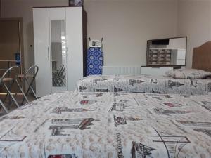two beds in a room with a quilt on it at moonlight apart otel in Erzincan