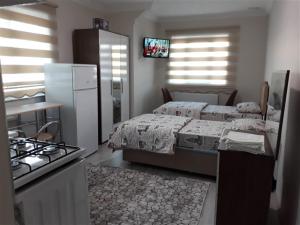 a bedroom with a bed and a kitchen with a stove at moonlight apart otel in Erzincan
