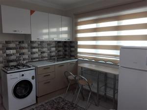 a kitchen with a sink and a washing machine at moonlight apart otel in Erzincan