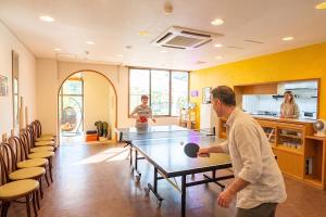 a man standing in a room with a ping pong table at アリビオ伊豆 in Ito +6 photos
