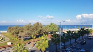 a view of a street with palm trees and the ocean at Spat Apartments in Bat Yam