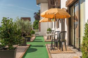 a patio with a table and chairs and an umbrella at Logis Hôtel Les 3B in Nouilhan