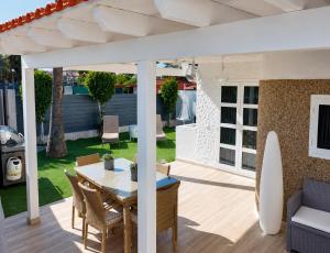 a patio with a table and chairs and a surfboard at Suite Coco in Maspalomas
