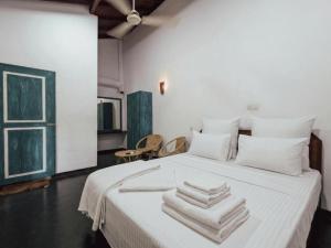 a bedroom with a white bed with towels on it at Galpothuyaya Eco Lodge Kandalama in Dambulla