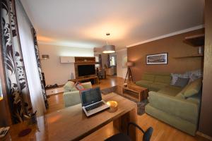 a living room with a laptop computer on a table at Rosehill Side Apartment in Budapest